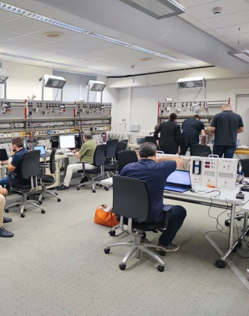 Session de formation KNX en salle : stagiaires devant des platines murales et des postes équipés d'ETS