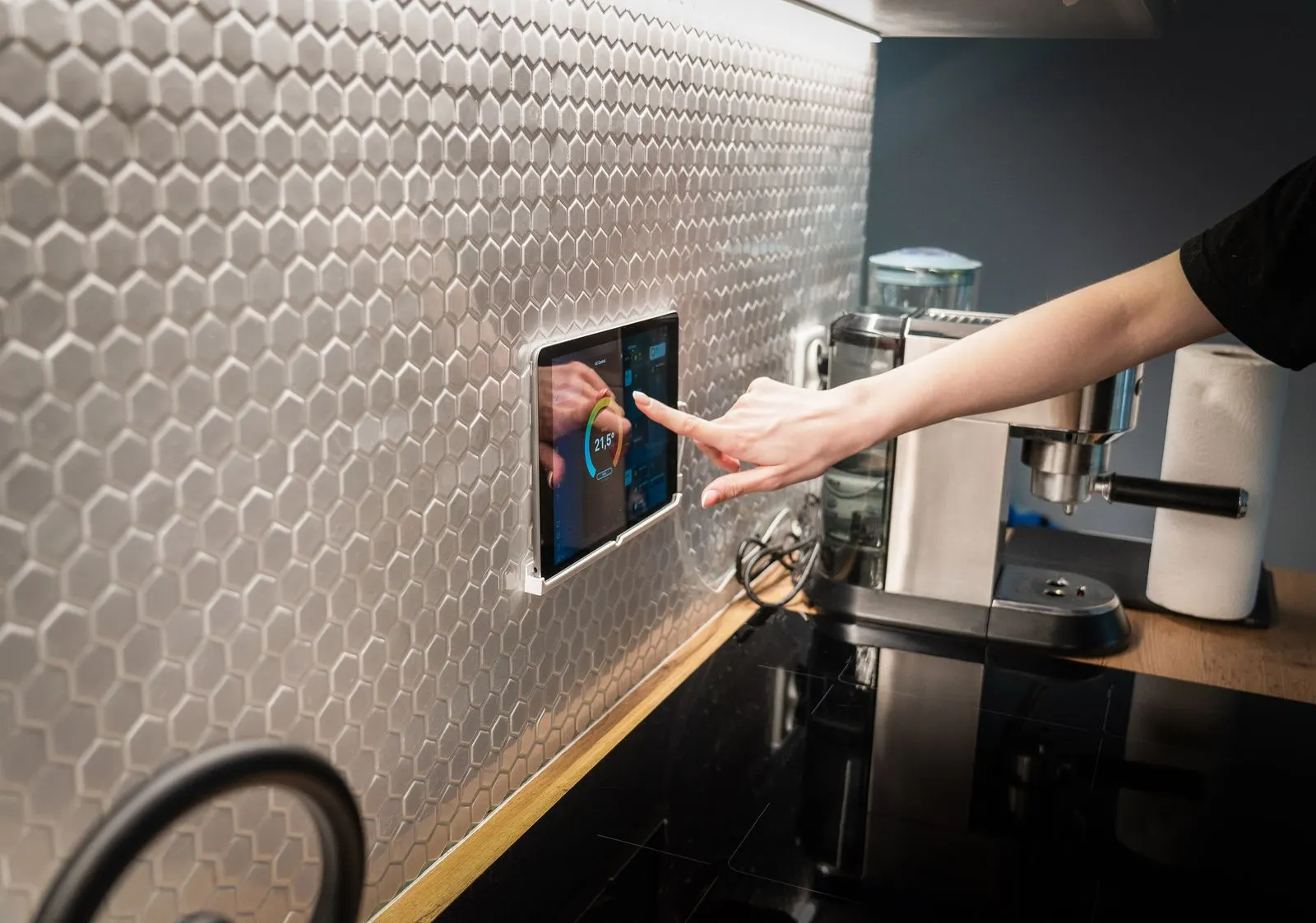 Tablette de contrôle domotique intelligente intégrée dans une cuisine, illustrant une installation électrique connectée aux normes actuelles
