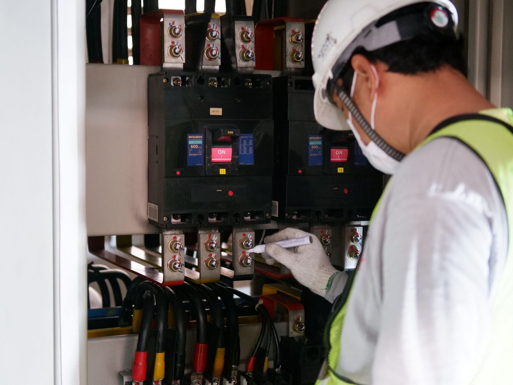 Technicien en équipement de protection individuelle contrôlant un tableau électrique, illustration de l'habilitation H0B0